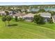 An aerial view of backyard featuring screened lanai, lush lawn, and tranquil water view at 14016 Fox Glove St, Winter Garden, FL 34787
