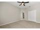 Neutral bedroom featuring carpeted floors, ceiling fan, closet and an adjacent bathroom at 14016 Fox Glove St, Winter Garden, FL 34787