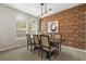 Elegant dining room featuring a long wooden table with seating for six and a decorative brick wall at 14016 Fox Glove St, Winter Garden, FL 34787