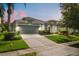 Charming single-story home featuring a well-manicured lawn and gray two-car garage and coordinated trim at 14016 Fox Glove St, Winter Garden, FL 34787