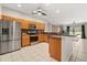 Open-concept kitchen with stainless steel appliances, warm wood cabinets, and an island with bar seating at 14016 Fox Glove St, Winter Garden, FL 34787