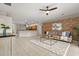 Open-concept living room featuring tile floors, brick accent wall, and seamless flow to kitchen at 14016 Fox Glove St, Winter Garden, FL 34787