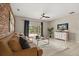 Inviting living room featuring a decorative brick wall, plush sofa, and a sliding glass door leading to the backyard at 14016 Fox Glove St, Winter Garden, FL 34787