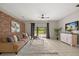 Inviting living room featuring a decorative brick wall, plush sofa, and a sliding glass door leading to the backyard at 14016 Fox Glove St, Winter Garden, FL 34787
