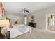 Bright main bedroom featuring a ceiling fan, ensuite bath, and sliding glass door to a screened patio at 14016 Fox Glove St, Winter Garden, FL 34787