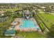 Aerial view of sparkling community pool and clubhouse, complete with ample seating and mature trees at 14016 Fox Glove St, Winter Garden, FL 34787