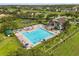 Aerial view of sparkling community pool and clubhouse, complete with ample seating and mature trees at 14016 Fox Glove St, Winter Garden, FL 34787