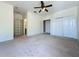 Large bedroom with neutral carpet, ceiling fan and a double closet at 14044 Chicora Crossing Blvd, Orlando, FL 32828