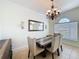 Elegant dining room featuring rustic wooden table, accent mirror, chandelier, and ceramic tile floors at 14044 Chicora Crossing Blvd, Orlando, FL 32828