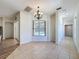 Bright dining room with a chandelier, tile flooring, and a view of the pool through a large window at 14044 Chicora Crossing Blvd, Orlando, FL 32828