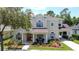 Charming two-story home featuring a landscaped yard, red front door and an attached covered garage at 14044 Chicora Crossing Blvd, Orlando, FL 32828