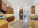 Modern kitchen with stainless steel appliances, granite counters, wooden cabinets, and neutral tile floors at 14044 Chicora Crossing Blvd, Orlando, FL 32828