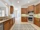 Well-lit kitchen boasting stainless steel appliances, wooden cabinets, and granite countertops at 14044 Chicora Crossing Blvd, Orlando, FL 32828