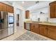 Bright kitchen featuring stainless steel appliances, granite countertops, wooden cabinetry, and tiled flooring at 14044 Chicora Crossing Blvd, Orlando, FL 32828