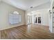 Bright living room showcasing hardwood floors, an arched entrance, and a decorative front door at 14044 Chicora Crossing Blvd, Orlando, FL 32828