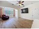 Bright living room with wood floors, ceiling fan, large windows, and a flat screen TV at 14044 Chicora Crossing Blvd, Orlando, FL 32828