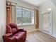 Bright living room with wood floors, large window with pool view, and a recliner chair at 14044 Chicora Crossing Blvd, Orlando, FL 32828