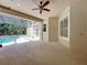 Open patio with ceiling fan overlooking screened-in pool and spa at 14044 Chicora Crossing Blvd, Orlando, FL 32828