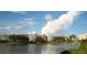 Picturesque waterfront view with buildings reflecting on the calm water on a beautiful partly cloudy day at 14044 Chicora Crossing Blvd, Orlando, FL 32828