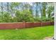 Backyard featuring a green lawn and brick fence, along with plenty of trees and shrubbery at 14213 Turning Leaf Dr, Orlando, FL 32828