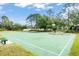 Community basketball court surrounded by trees and green grass, with a park bench at 14213 Turning Leaf Dr, Orlando, FL 32828