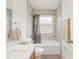 Bright bathroom featuring a shower over the tub with a tiled wall and a white vanity with a towel rack at 14213 Turning Leaf Dr, Orlando, FL 32828