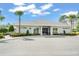 Exterior view of a clubhouse with plenty of parking and a well-manicured lawn and green shrubbery at 14213 Turning Leaf Dr, Orlando, FL 32828