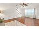 Bright living room with wood floors, ceiling fan, and large windows for natural light at 14213 Turning Leaf Dr, Orlando, FL 32828