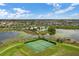 Expansive aerial view showcases the community's pool, tennis courts, lake, and well-maintained landscaping at 15477 Blackbead St, Winter Garden, FL 34787