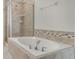 Relaxing bathroom features a soaking tub with tiled surround and glass shower enclosure at 15477 Blackbead St, Winter Garden, FL 34787