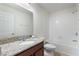 Bright bathroom features a granite countertop, framed mirror, and a shower over tub at 15477 Blackbead St, Winter Garden, FL 34787