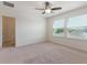 Light-filled bedroom with neutral walls, two windows, and ceiling fan at 15477 Blackbead St, Winter Garden, FL 34787