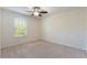 A bright bedroom with neutral carpet, ceiling fan, and a large window lets in lots of natural light at 15477 Blackbead St, Winter Garden, FL 34787