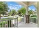 Inviting front porch with stone columns, white railing, and serene neighborhood views at 15477 Blackbead St, Winter Garden, FL 34787