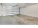 Empty, clean single-car garage with white walls and ceiling and concrete floor showing garage door hardware at 15477 Blackbead St, Winter Garden, FL 34787