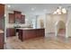 Open-concept kitchen with an island, stainless appliances, and wood flooring at 15477 Blackbead St, Winter Garden, FL 34787