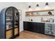 An elegant bar area with custom cabinets, open wood shelving, and a beverage center for entertaining at 15779 Tangerine Dream Ct, Winter Garden, FL 34787