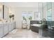 Well lit bathroom features dual sinks, a glass enclosed shower, and a soaking tub at 15779 Tangerine Dream Ct, Winter Garden, FL 34787