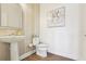 Stylish half bathroom with pedestal sink, decorative wallpaper, floral artwork, and wood-look flooring at 15779 Tangerine Dream Ct, Winter Garden, FL 34787