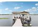 Waterfront boat dock features a covered area, seating, and space for multiple boats at 15779 Tangerine Dream Ct, Winter Garden, FL 34787