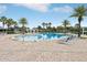 Beautiful community pool area with lush landscaping, inviting lounge chairs, and a sparkling blue swimming pool at 15779 Tangerine Dream Ct, Winter Garden, FL 34787