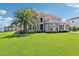 Beautiful two-story home with lush landscaping, stone accents, and a well-manicured lawn at 15779 Tangerine Dream Ct, Winter Garden, FL 34787