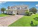 Spacious two-story home with a paver driveway, multiple garage doors, and manicured lawn at 15779 Tangerine Dream Ct, Winter Garden, FL 34787
