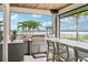 A luxurious outdoor kitchen features a stainless steel grill and bar seating with stunning waterfront views at 15779 Tangerine Dream Ct, Winter Garden, FL 34787
