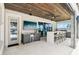Outdoor kitchen and entertaining space with a tv, built in bar, and water views at 15779 Tangerine Dream Ct, Winter Garden, FL 34787