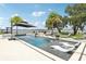 Resort-style pool with integrated lounge chairs, black umbrella, and water views at 15779 Tangerine Dream Ct, Winter Garden, FL 34787