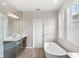 Bright bathroom with soaker tub, glass shower, and wood-look tile flooring at 16013 Tollington Aly, Winter Garden, FL 34787