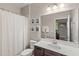Clean bathroom featuring a white shower curtain, framed art, and a vanity with a white countertop at 16013 Tollington Aly, Winter Garden, FL 34787