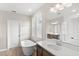 Bright bathroom with soaker tub, glass shower, wood-look tile flooring, and double vanity at 16013 Tollington Aly, Winter Garden, FL 34787