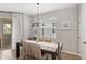 Bright dining area with a wooden table, neutral chairs, and natural light from a sliding door at 16013 Tollington Aly, Winter Garden, FL 34787
